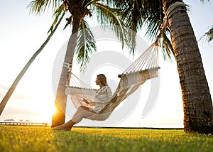 Girl in a hammock bother palm trees enjoying a tropical vacation