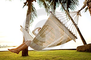 Girl in a hammock bother palm trees enjoying a tropical vacation