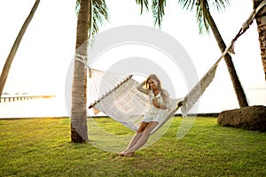 Girl in a hammock bother palm trees enjoying a tropical vacation