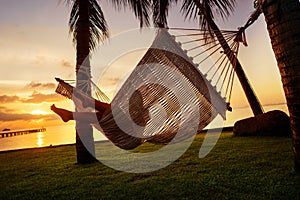 Girl in a hammock bother palm trees enjoying a tropical vacation