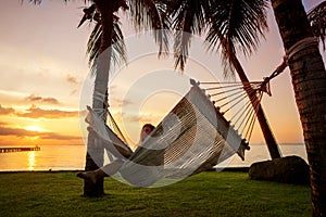 Girl in a hammock bother palm trees enjoying a tropical vacation