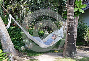 Girl in a hammock between two palm trees