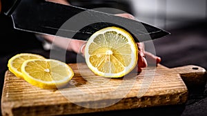 Girl hand cutting lemon with knife closeup