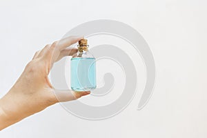 Girl hand holding ethanol alcohol in glass bottle