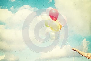 Girl hand holding multicolored balloons