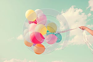 Girl hand holding multicolored balloons