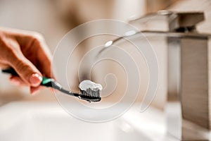 Girl hand holding tooth brush with paste under running water