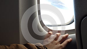 Girl hand on an illuminator of aircraft just before takeoff