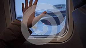 Girl hand on an illuminator of aircraft just before takeoff and fly away