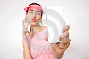 Girl with hand peace sign taking selfie with cell phone