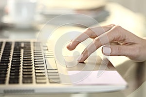 Girl hand using touchpad on a laptop at home