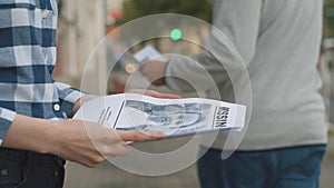 Girl handing out leaflets about the missing child,close up