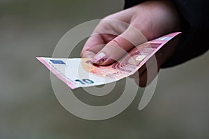 Girl hands giving money. Holding EURO banknotes on a blurred background