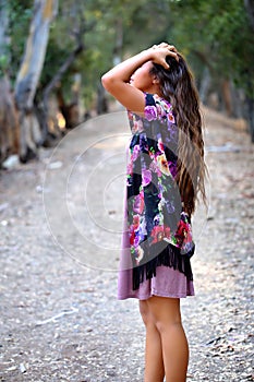 Girl with hands in hair on a path