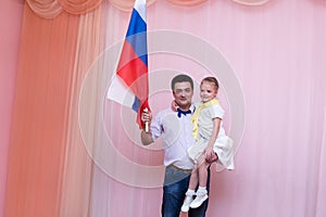 Girl in hands of her father with the flag