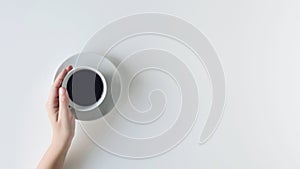 Girl hands holding cup with black coffee on the white table. flat lay, top view. coffee art.