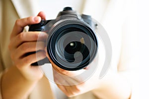 Girl hands holding photo camera, white background, copy space. Travel and shoot concept