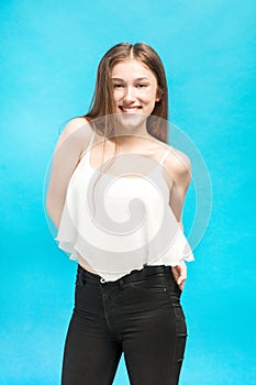 Girl with hands in pockets smiles broadly photo