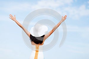 Girl with hands up on the beach