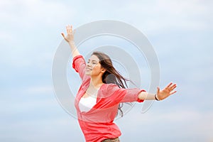 Girl with hands up on the beach