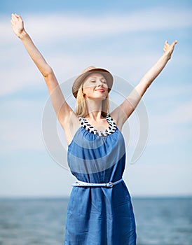 Girl with hands up on the beach