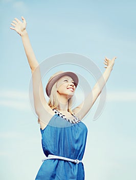 Girl with hands up on the beach