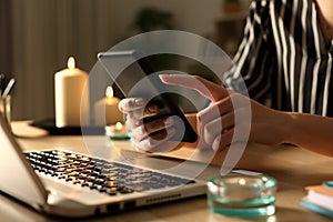 Girl hands using phone on power outage with candles