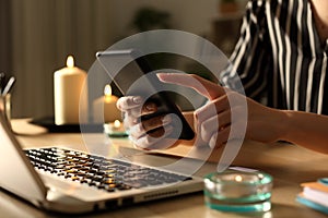 Girl hands using phone on power outage with candles photo