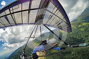 Girl hang glider pilot soars in the mountains