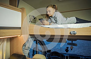 Girl Hanging on Bunk Camper Bed with Her Smartphone