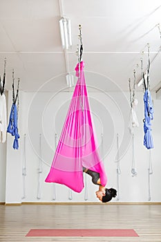 Girl hanging in hammock in upside down inversion pose.