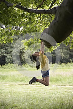 Girl Hanging From Tree Branch