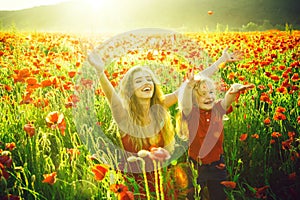 Girl and little boy or child in field of poppy