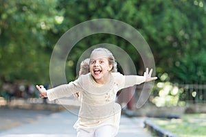 Girl on happy smiling face, nature on background. Child happy and cheerful enjoy walk in park. Happiness concept. Kid