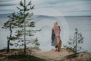 A girl with a harp stands on the lake