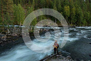 A girl with a harp stands on the river