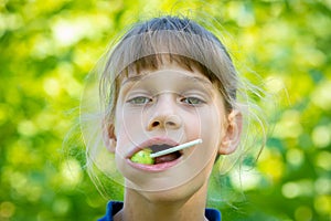 The girl has a big round lollipop in her mouth, close-up portrait