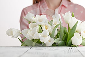 Girl has just bestowed a bouquet of white tulips