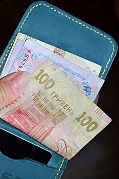 the girl has a purse with Ukrainian money in her hands