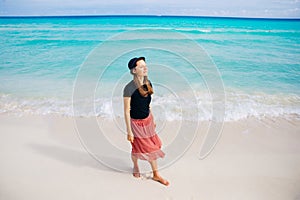 Girl in a hat on a background of the ocean. Beautiful girl looks at the sea