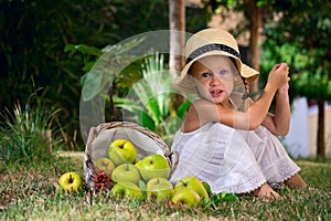 Girl in a hat and a basket of apples