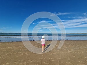 Girl with hat in front of the sea, on a sandy beach. Valdelagrana Beach photo