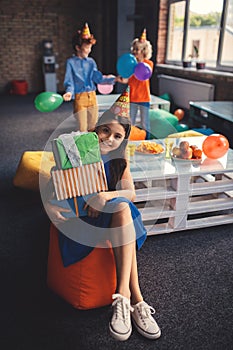 Girl in a hat holding presents and looking pleased