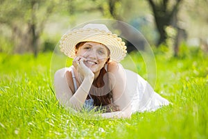 Girl in hat lying on grass