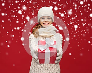 Girl in hat, muffler and gloves with gift box
