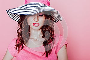 The girl in the hat on a pink background pinup