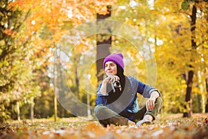 Girl in hat with professional camera on fall season park