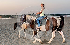 Girl with a hat riding a horse