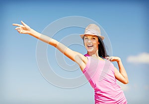 Girl in hat showing direction on the beach