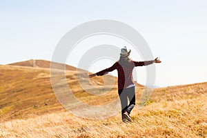 Girl with hat walk with happiness on top of mountain range in autumn